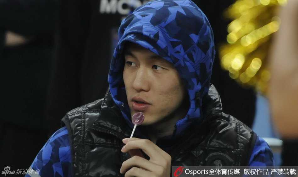 秋日暖阳下的球场童趣:郭艾伦热身赛“全副武装”吃糖记 身穿长款厚实羽绒服的郭艾伦坐在场边,嘴里含着棒棒糖,眼神专注又带着一丝惬意,仿佛寒冷的天气与他无关,只有手中的甜蜜才是此刻最重要的事。