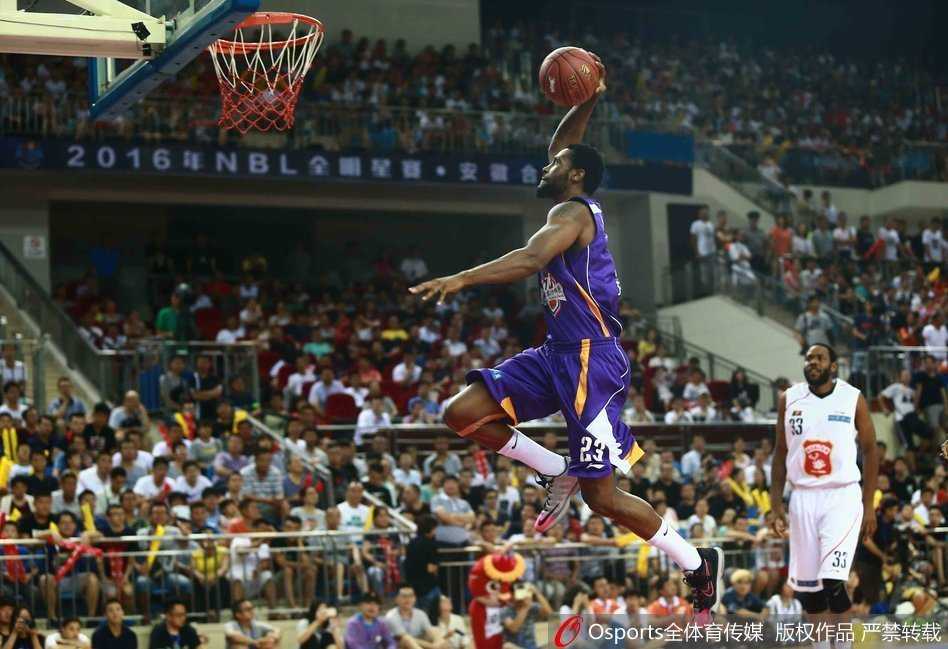 篮球场上的进攻艺术:从飞身暴扣到篮下终结 球员高高跃起,以一记势大力沉的双手暴扣终结进攻,篮筐在他手中颤抖。