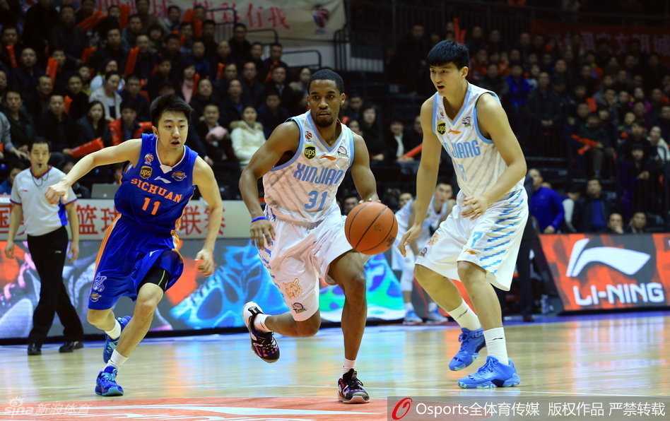 新疆队防守悍将西热力江在拼抢中受伤，痛苦地躺倒在地板上，双手紧捂受伤部位，队友们围拢过来神情关切，场边队医也迅速进场查看伤情。