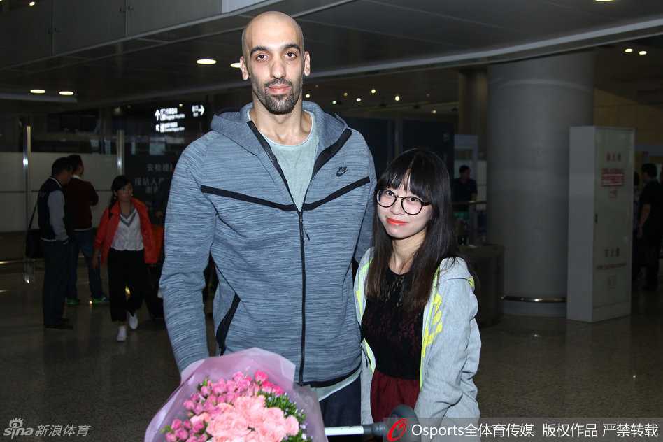 阿巴斯在抵达仪式上与江苏同曦俱乐部人员交流，背景是球队的训练基地，金陵秋日的阳光下，一段全新的篮球冒险就此开启。