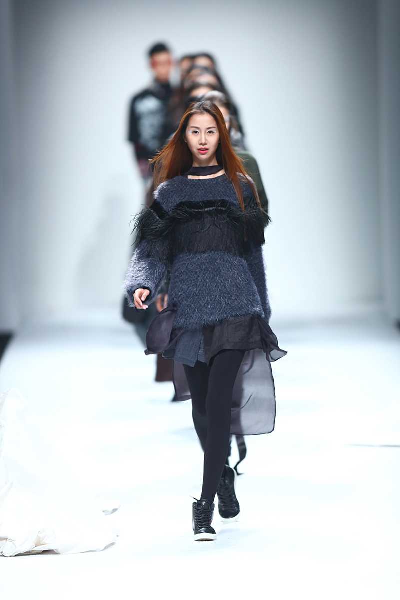 陈露身着一袭飘逸的白色长裙行走在T台上，衣袂翩翩，简约的造型衬托出她优雅迷人的气质，仿佛从画中走出的仙子