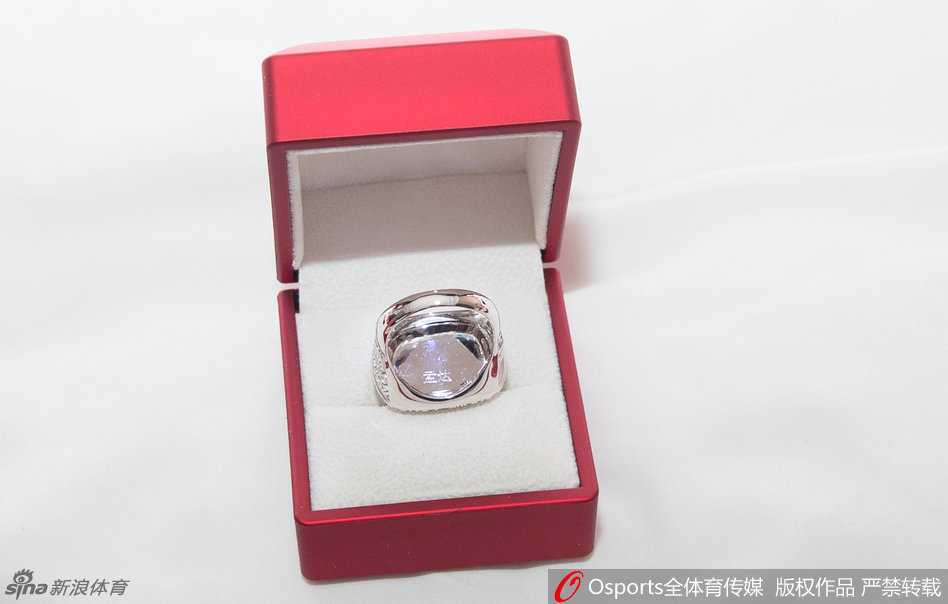 蜀地荣光揭秘:镌刻在总冠军戒指上的铁血传奇 球队主帅杨学增指导微笑着站在队员中间,他手中同样拿着一枚属于自己的总冠军戒指,身后是看台上挥舞着旗帜、欢呼雀跃的四川球迷