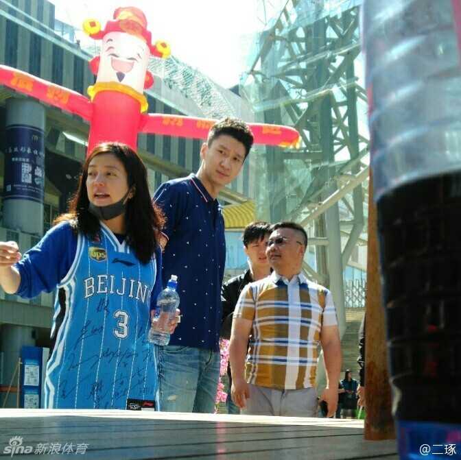 导演赵薇身穿写满签名的马布里3号球衣，站在监视器前，眼神专注地审视着镜头里的画面，口罩也遮不住她工作的认真劲儿。