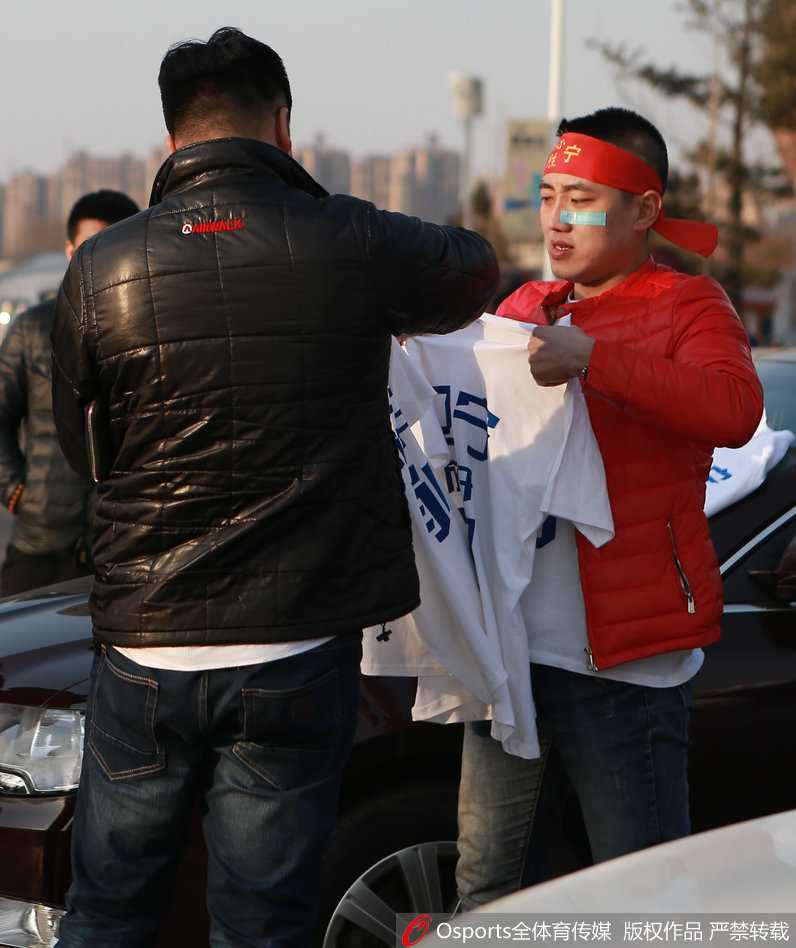 在场馆边，几名辽宁球迷兴奋地展开助威T恤，T恤上的球员写真与球迷的笑脸相映成趣，他们正在用最响亮的口号为即将上场的子弟兵打气。