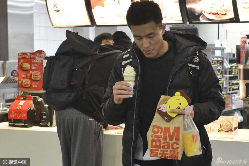 郭艾伦手举蛋筒冰淇淋正在结账，脸上带着一丝狡黠的笑容，仿佛在说偷偷享受这一刻的美味。