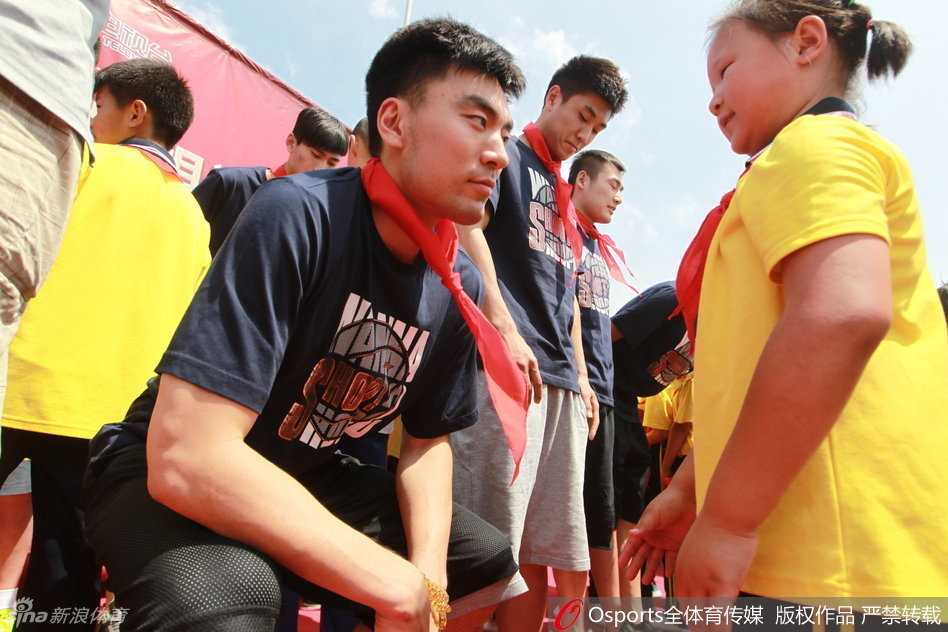 辽篮将士情暖岫岩山村小学 篮球梦想在山沟沟里萌芽 在简陋的篮球架下,李晓旭俯身与一名小朋友亲切击掌,鼓励他在球场上要勇敢和自信,身后是围观同学们开心的笑容。