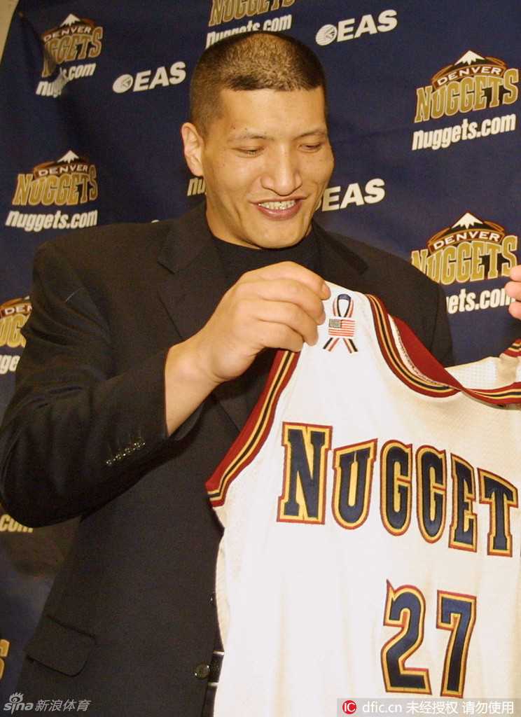 画面中，姚明正以标志性的动作准备封盖对手的投篮。他的存在本身就是一道难以逾越的屏障，无数进攻在他的巨掌下无功而返，这张照片凝固了他作为顶级护筐者的威严瞬间。