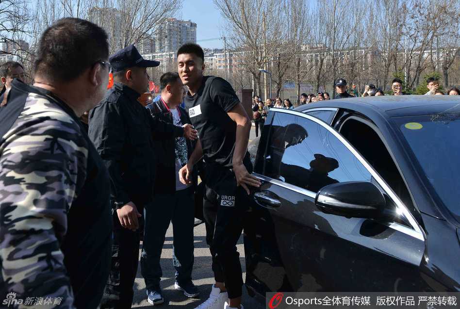 活动场地周围挤满了热情的球迷，他们高举着手机和应援牌，目光齐刷刷地投向正在场中活动的郭艾伦，现场气氛热烈至极。