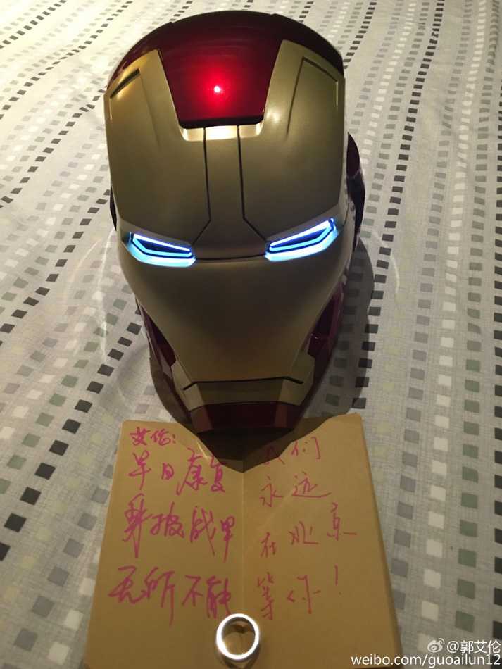 郭艾伦戴着完整的头盔侧身站立，展现出头盔完美的流线型轮廓，他一只手轻轻扶着下颌部位，活脱脱就是电影里走出的托尼·斯塔克。