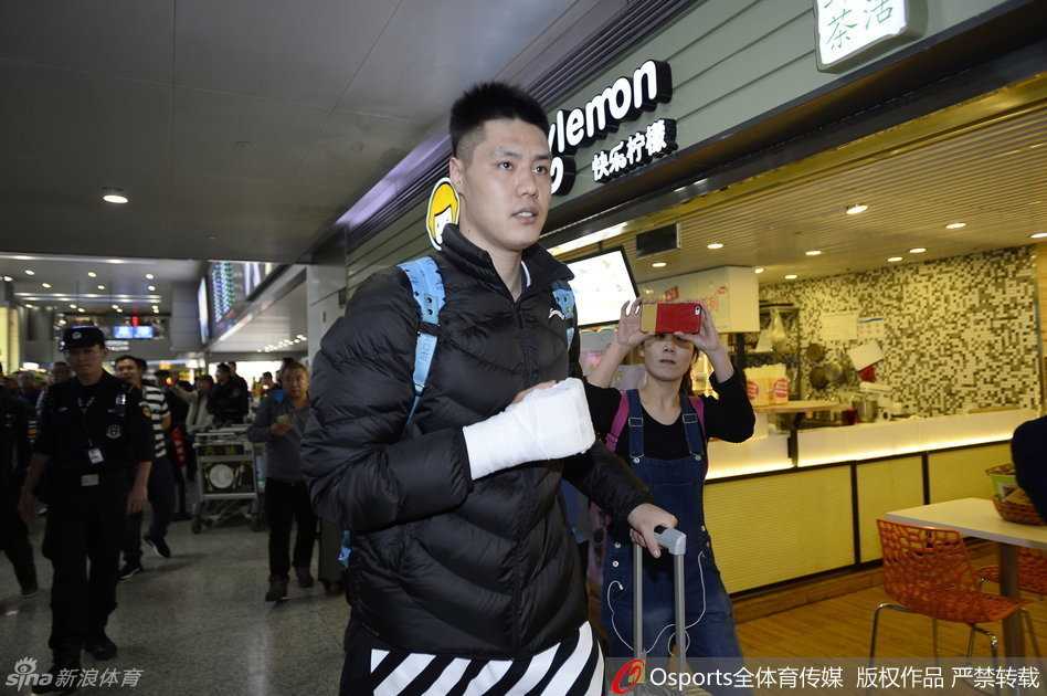 铁血柔情与创可贴的印记:辽篮三将成都归队记 身穿红色外套的刘志轩低头快步行走,身旁的安保人员警觉地观察着四周,身后的球迷们举着手机,试图记录下这历史性的一刻。