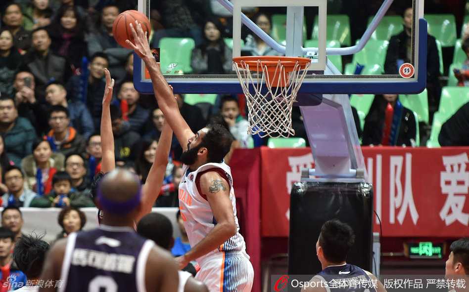 王哲林穿着便装坐在场边，眼神焦急地望着场内，不能上场的遗憾和对队友的关切，全都写在了他那紧锁的眉头上。