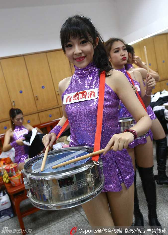 舞台中央，这位拿着鼓槌的宝贝化身‘打鼓小公主’，每一次有力的敲击都伴随着身体的律动，红色的流苏随着动作飞扬，仿佛在用最原始的音乐节奏点燃全场球迷的热情。