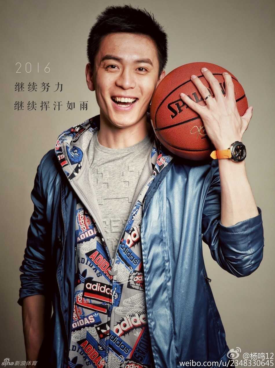 杨鸣在球场持球，眼神专注而坚定，阳光洒在他身上尽显运动健将的迷人风采