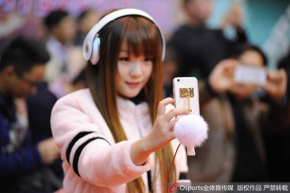 这位身材惹眼的女球迷在场边安静地观看比赛，侧面轮廓优美，她手中拿着助威棒，背景是激烈的赛场对抗。