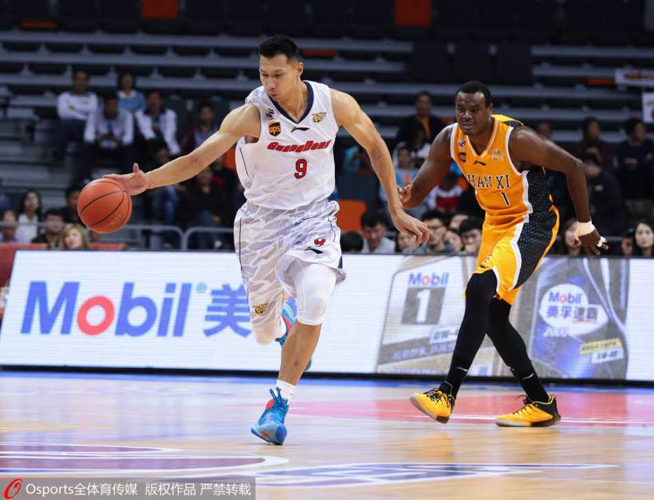 眼神坚毅的易建联在场上全力要球，身后防守球员如影随形，领袖气质尽显无遗。