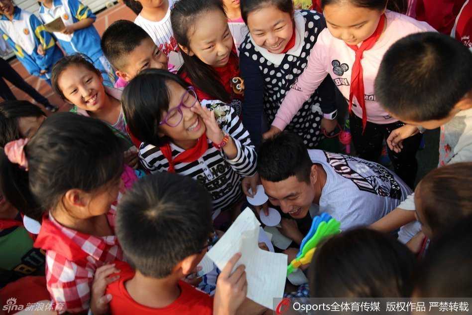首钢男篮校园行:当篮球梦想照进现实,翟晓川与孩子们的温暖邂逅 吉喆和翟晓川正在为小朋友们做投篮示范,两人高大的身影与孩子们形成鲜明对比,吉喆认真指导动作,孩子们目不转睛地学习