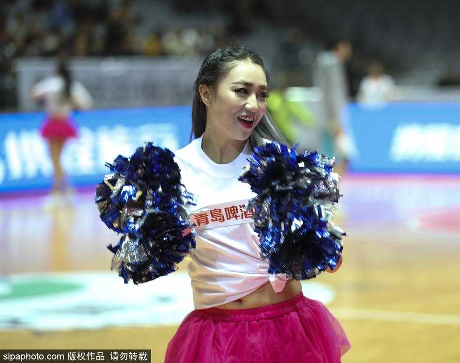 在绚丽的赛场灯光下，全体篮球宝贝摆出充满活力的舞蹈造型，她们的动作整齐划一，笑容甜美，与身后巨大的CBA标志交相辉映，构成一幅动人的画面。