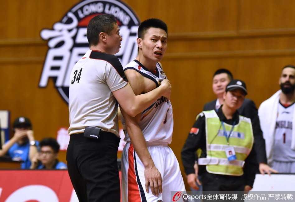 身穿白色球衣的天津队球员和深色球衣的广州队球员面对面怒目而视，旁边的队友赶紧搂住己方球员的腰部往后拖，试图平息这场一触即发的争斗。