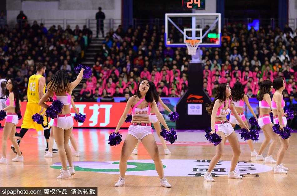 蓝色裙摆在灯光下闪烁，篮球宝贝们面带灿烂笑容，用热情的舞姿感染着看台上的每一位球迷