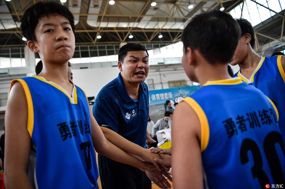 暂停时间，教练快速地向围成一圈的小球员们讲解战术，他手中比划着战术路线，眼神坚定，队员们则个个凝神静听，充满信任。