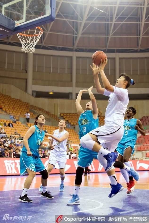 广东队核心球员在包夹之下强行突破，眼神坚毅，肌肉线条在对抗中绷紧，展现出极强的核心力量。