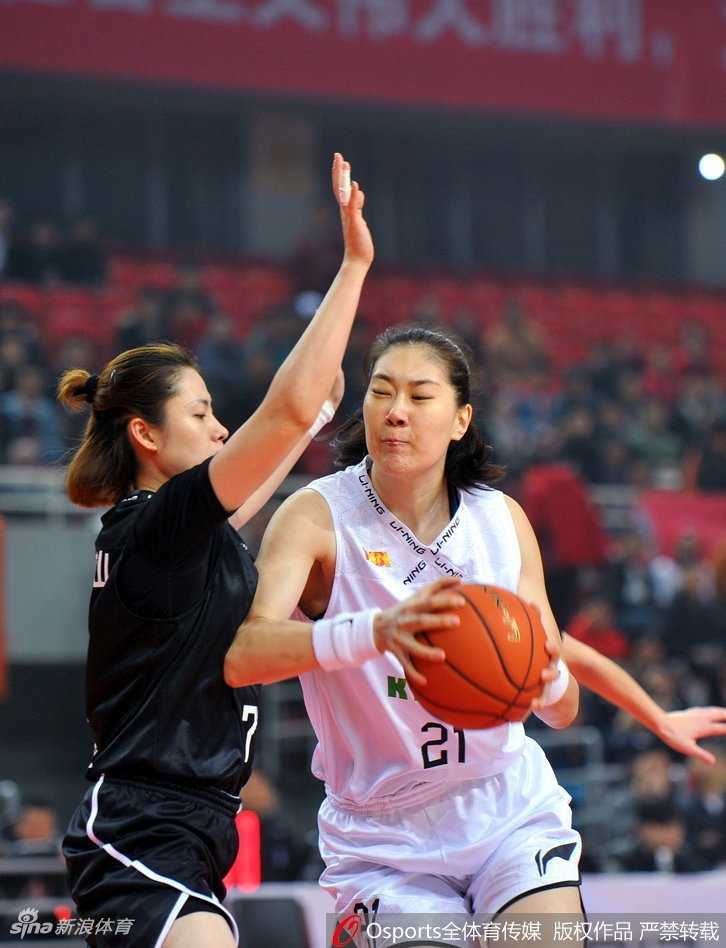 WCBA联赛第八轮激战 江苏女篮客场力擒八一 八一女篮核心中锋在江苏队多人包夹之下依然高举高打,眼神坚毅望向篮筐