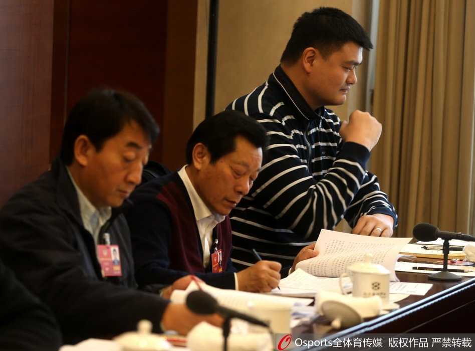 “小巨人”的大智慧:姚明在两会上的篮球改革与体育强国梦 一身深色西装的姚明被记者围在人民大会堂前的空地上,他微微低头,神情专注地听着记者提问,四周的话筒和录音笔如林,几乎要贴到他身上,他身后不远处就是巍峨的建筑。