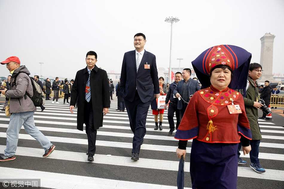 “小巨人”的大智慧:姚明在两会上的篮球改革与体育强国梦 姚明在人民大会堂的台阶上被围得水泄不通,他双手自然下垂,耐心地挪动脚步,身边的女记者高举录音笔,脸上带着急切而兴奋的笑容,场面热烈而有序。