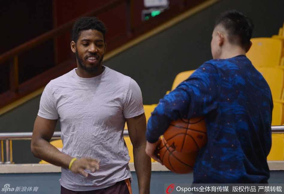 球员们围拢在一起，气氛显得有些紧张，似乎是一次训练中的意外受伤让大家暂时停下了脚步，都在关注着伤者的情况。