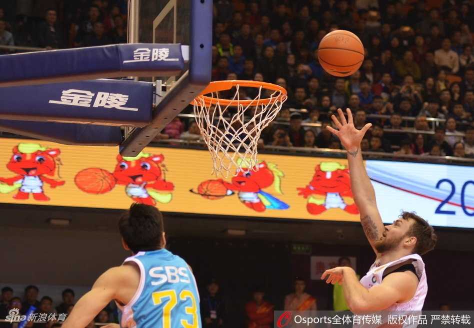 王哲林篮下强攻遭遇山东男篮三人合围，他奋力跃起试图双手灌篮，却在天罗地网般的防守下未能得手，表情写满无奈。