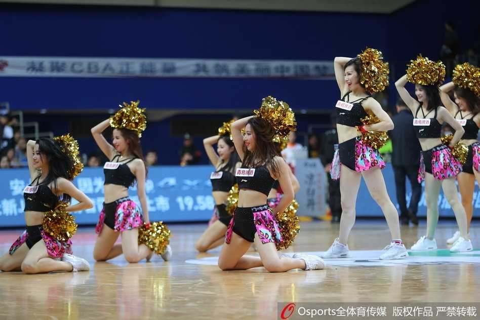 镜头聚焦于一位正在热舞的啦啦队女生，她面带甜美笑容看向侧面，紧身露脐装勾勒出优美的身体线条，动感的姿态定格了青春活力的瞬间。