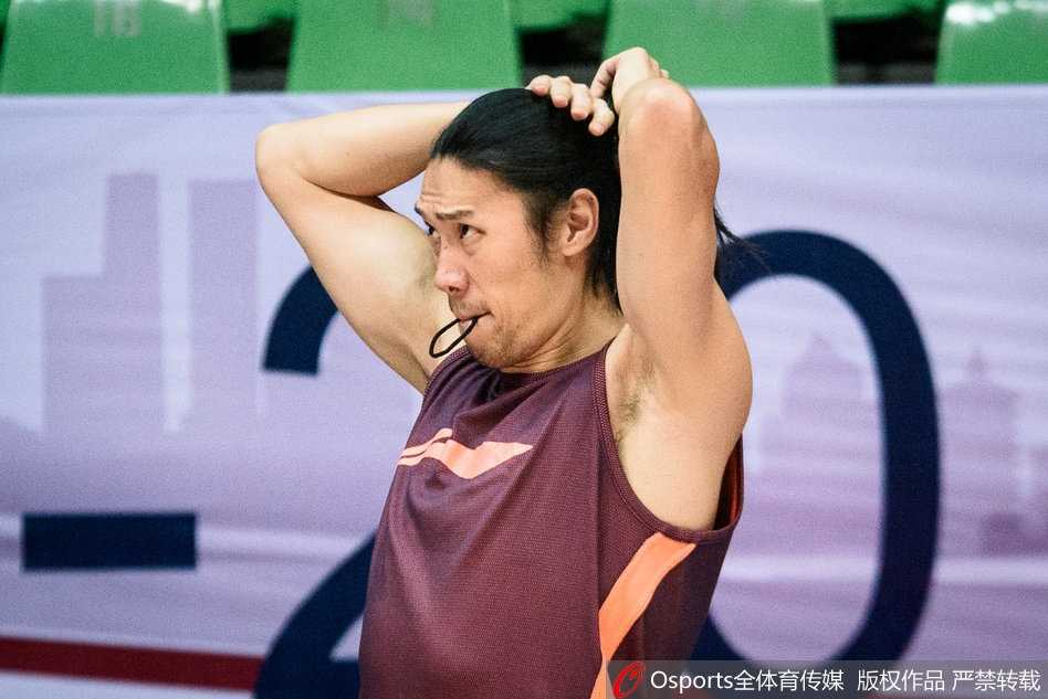 明纳拉斯在训练间隙拉伸放松，专注的眼神透露出职业球员的严谨，手臂上的纹身在灯光下格外显眼。