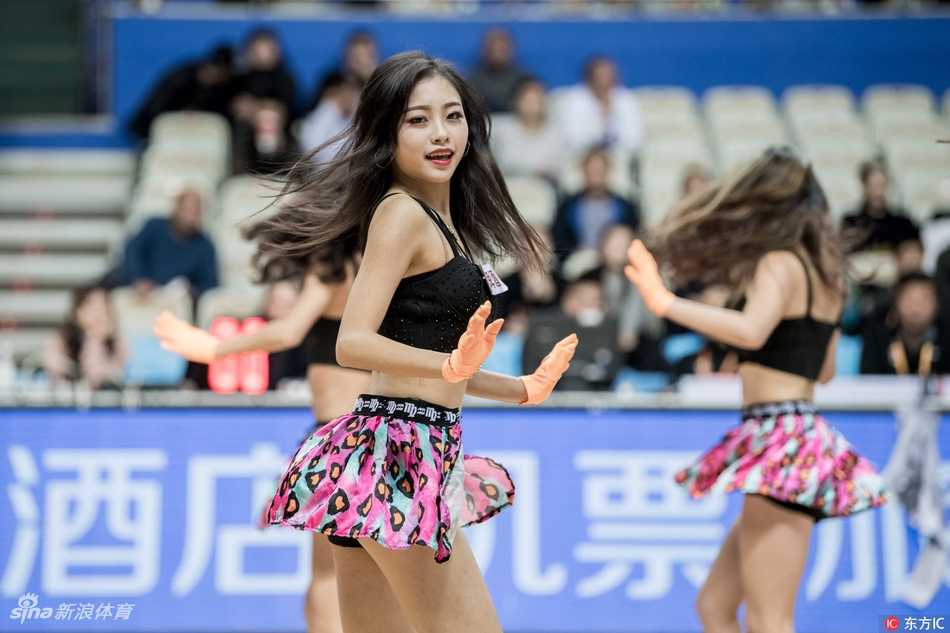 上海滩的甜美火力:大鲨鱼啦啦队主场热舞燃爆源深 舞蹈进行到高潮部分,两名拉拉队员面对面热舞,她们的动作充满张力与默契,飞扬的发丝和自信的笑容在灯光下闪闪发光,展现出职业拉拉队的专业素养和青春活力。