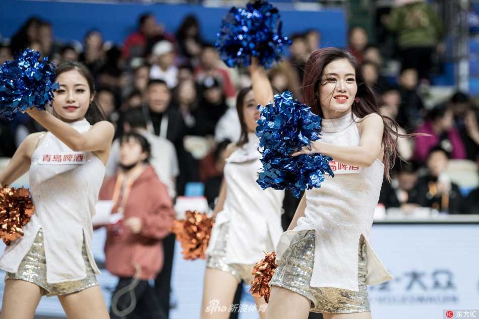 啦啦队成员们在场上围成一圈，伸展手臂展现出优美的身体曲线，仿佛一群优雅的白天鹅在霞光下舞动