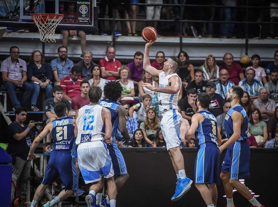 世预赛南美区经典战:阿根廷83-88乌拉圭,“钻石”斯科拉独木难支 斯科拉在禁区内卡位要球,他身后的乌拉圭防守球员表情狰狞,试图用身体顶防阻止这位经验丰富的内线大师接球。