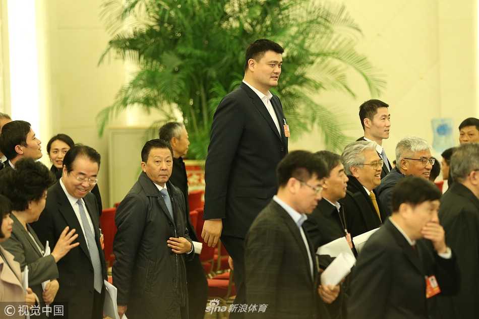 人潮涌动的天安门广场上，身高达两米二六的姚明与乒乓球世界冠军王励勤并肩走出人民大会堂，两人神情轻松，边走边交流着刚刚开幕会的心得，周围的其他代表委员在他们身边形成了一道独特的风景线。