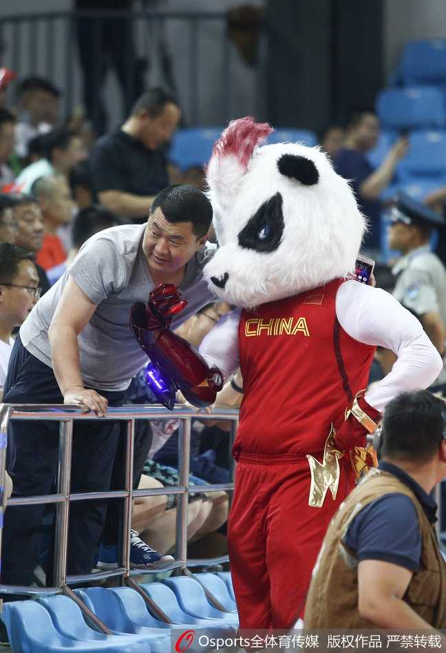 吉祥物与啦啦队队员击掌互动，它憨厚可爱的造型与啦啦队姑娘们的笑容相映成趣，现场气氛欢乐。