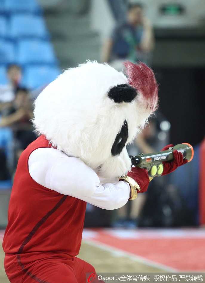 吉祥物背对镜头，双手叉腰看着大屏幕上的比分，背影里既有比赛的紧张感，也有守护主队胜利的满足感。