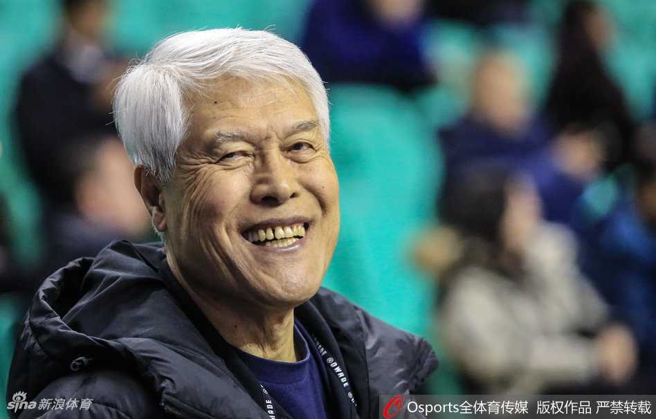 蒋兴权指导与弟子在场边低声交流，他的手势仿佛正在传授赛场上的玄机，眼神交汇间传递着信任与战术的奥秘，这是篮球智慧的传承。