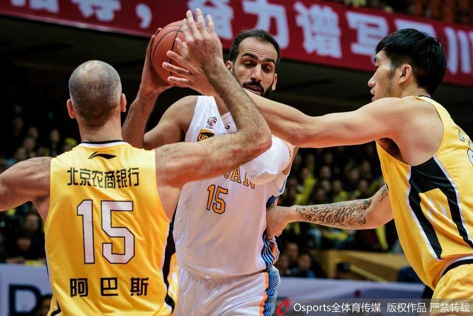 北控球员兰多夫在四川队的严密防守下强行突破，肌肉的碰撞和坚定的眼神，彰显着比赛的激烈对抗。