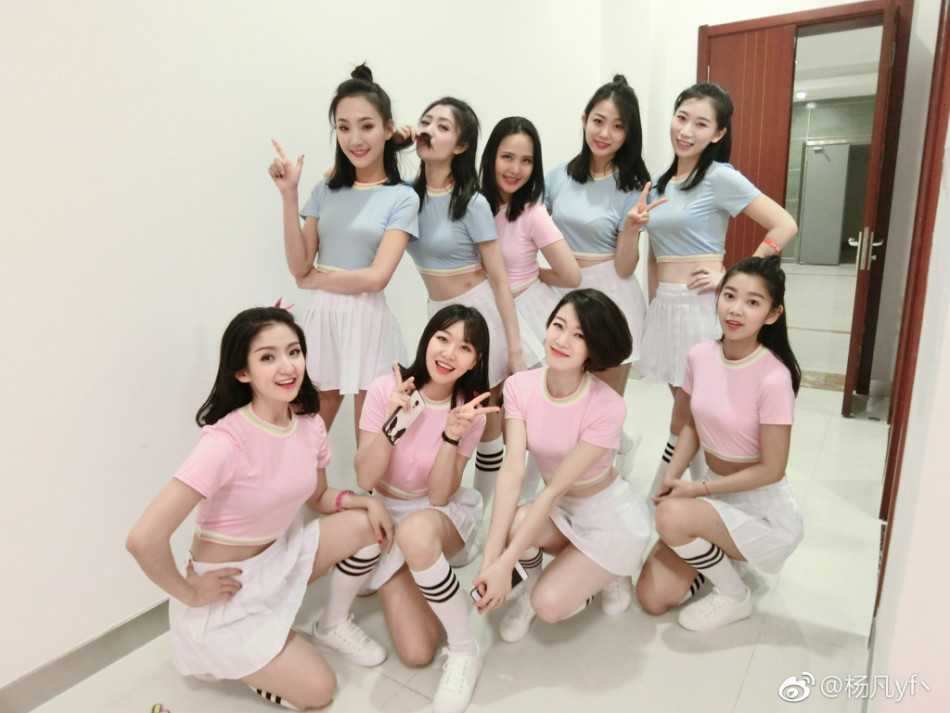 休息间隙，几位空姐啦啦队员围坐在一起比出胜利手势，脸上洋溢着灿烂的笑容，身后的比分牌记录着比赛的激烈