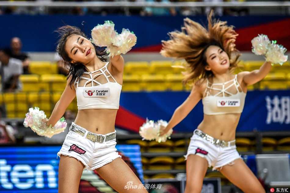 篮球宝贝们扎着清爽的马尾，身着亮黄色露脐战袍，在赛场中央随着音乐尽情舞动，青春的活力与完美的身材曲线一览无余。