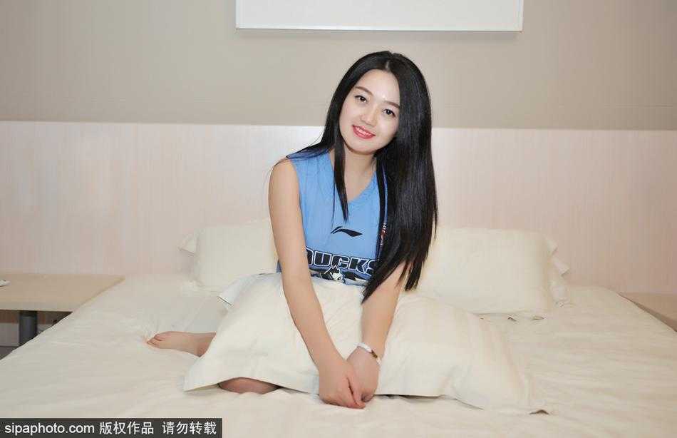 京城佳话:美女球迷火辣助阵,首钢男篮剑指荣耀之巅 画面中的女孩安静地坐在床边,手托下巴,眼神温柔却坚定。她身穿的休闲服上,一枚小小的首钢队徽在灯光下闪闪发亮,细节之处尽显铁粉本色。