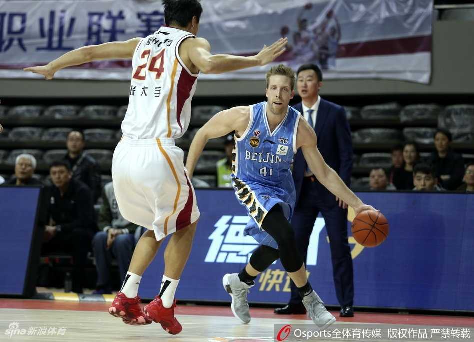 尽管比分落后，浙江队的国内核心球员依然没有放弃，他试图在人群中找到空位的队友，眼神中充满不甘与坚毅。