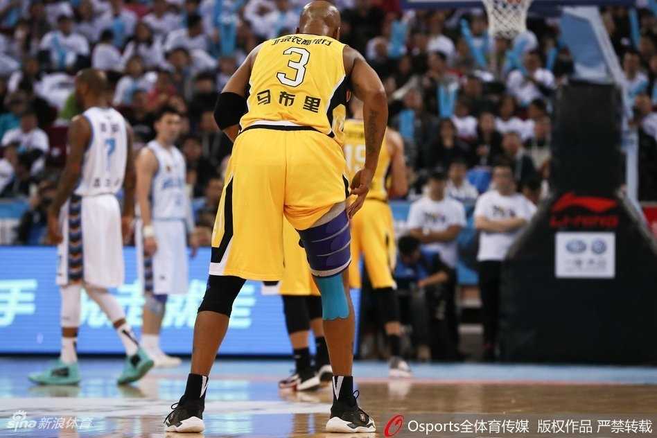 京城德比不朽魂,马布里五棵松摘护具搏命一击 马布里持球强行突破,面对两名防守球员的包夹封堵,他咬紧牙关腾空而起,身体在空中扭曲成一张弓,奋力将球抛向篮筐。