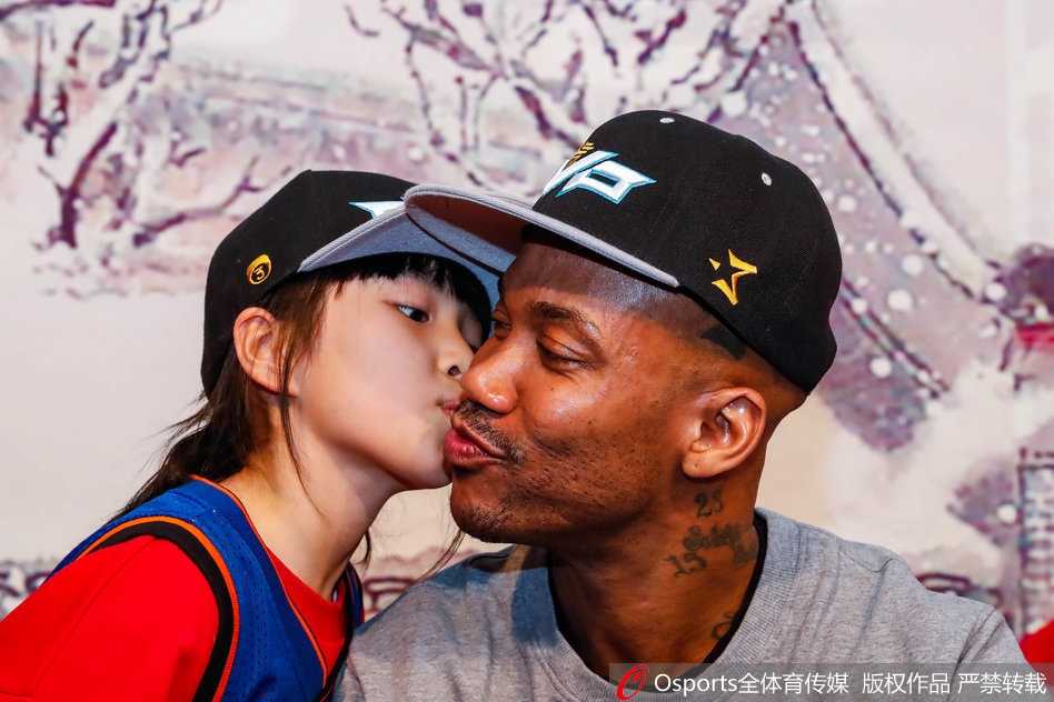 人潮涌动的见面会现场，身着红色卫衣的小球迷踮起脚尖，用小手捧着马布里的脸，献上了一个纯真而深情的吻，老马闭眼弯腰，满是胡茬的脸上露出慈祥的笑容，仿佛瞬间被这个吻融化了心。