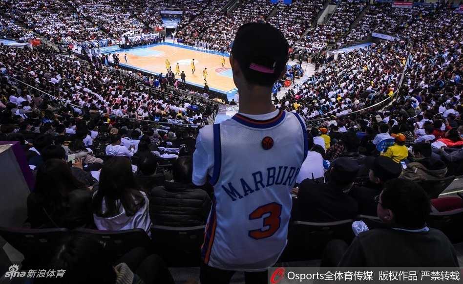 赛前热身时，吉祥物在场边与小朋友们亲密互动，巨大的队旗在看台上迎风招展，整个球馆沉浸在一种节日般的欢乐与期待之中。