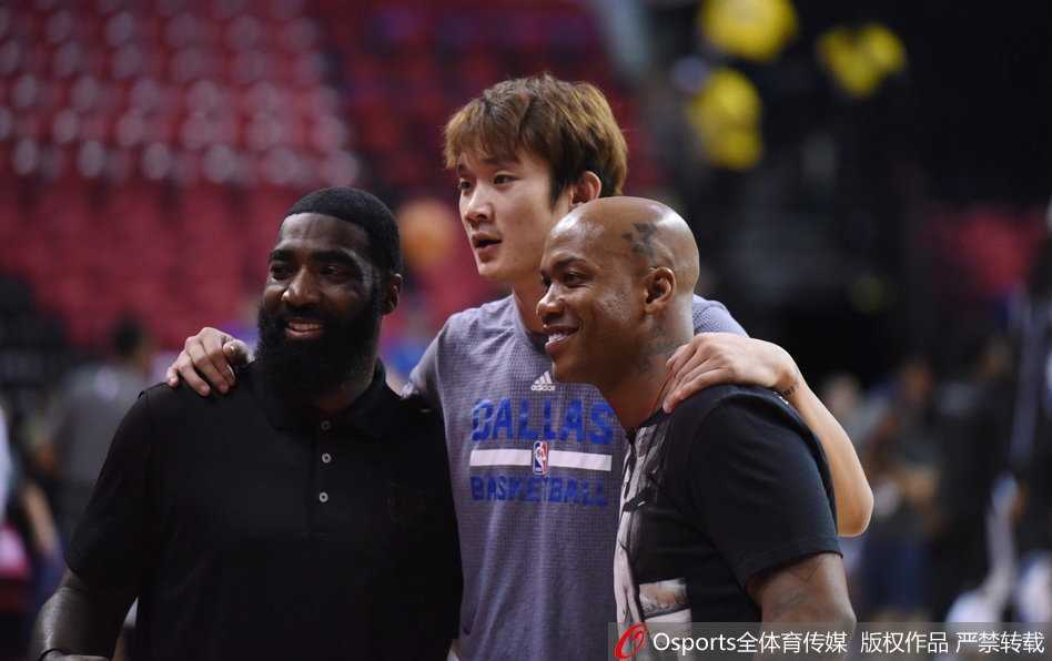 身着白色T恤的马布里与身穿小牛训练服的丁彦雨航面对面站着，两人双手紧握，眼神交汇，像是一场郑重的托付与承诺。