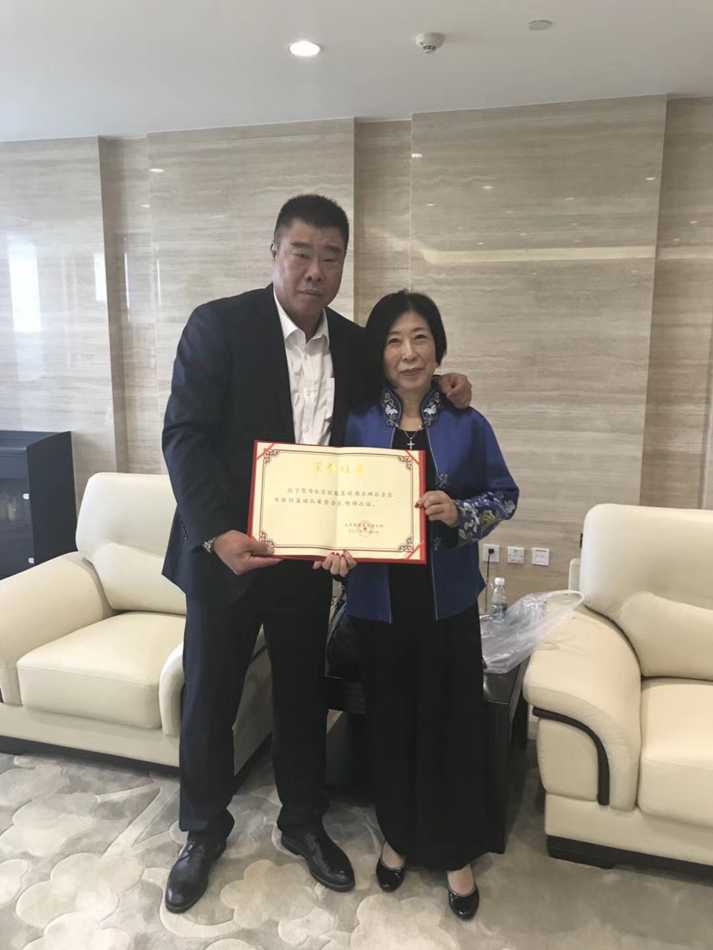 球队总经理将一面印有金色“捐赠纪念”字样的牌匾授予张阿姨，感谢她对球队的无私奉献，张阿姨双手接过，眼中闪烁着激动的光芒。