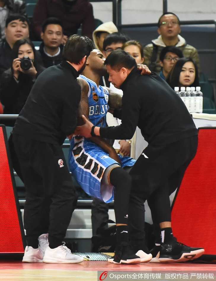 杰克逊在多人包夹下痛苦倒地，手捂肩膀，面部表情因剧痛而扭曲